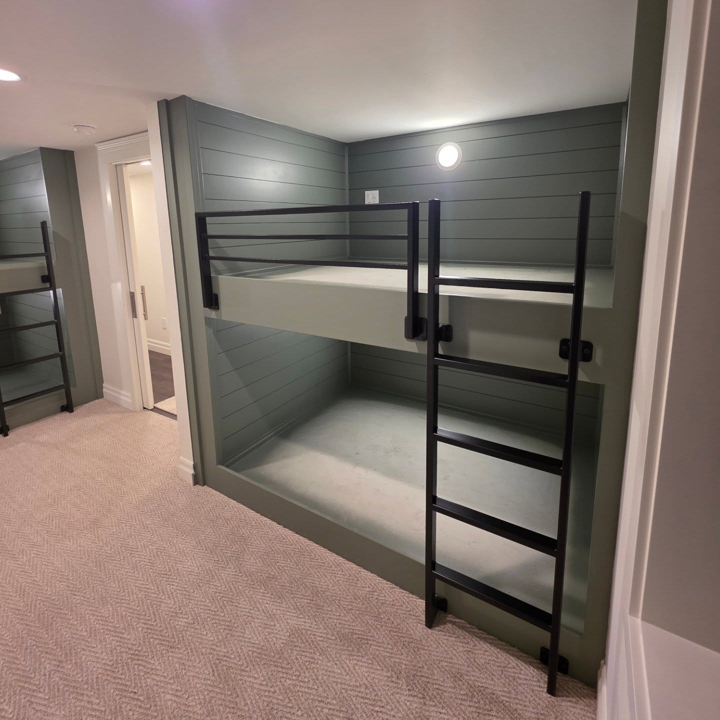 Custom built-in bunk beds with shiplap, matte black ladders, and built-in lighting in Manson WA