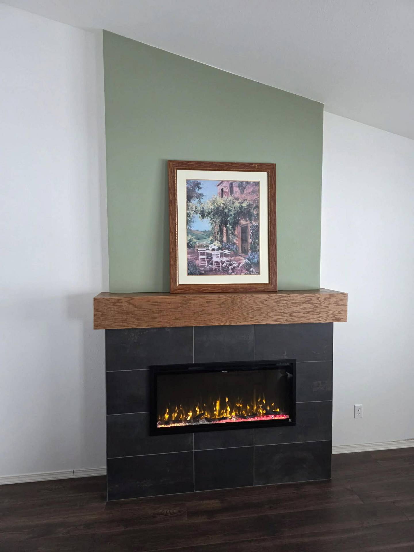 Modern fireplace upgrade with white oak mantle and sage accent panel in Manson WA by Garcia Home Renovations